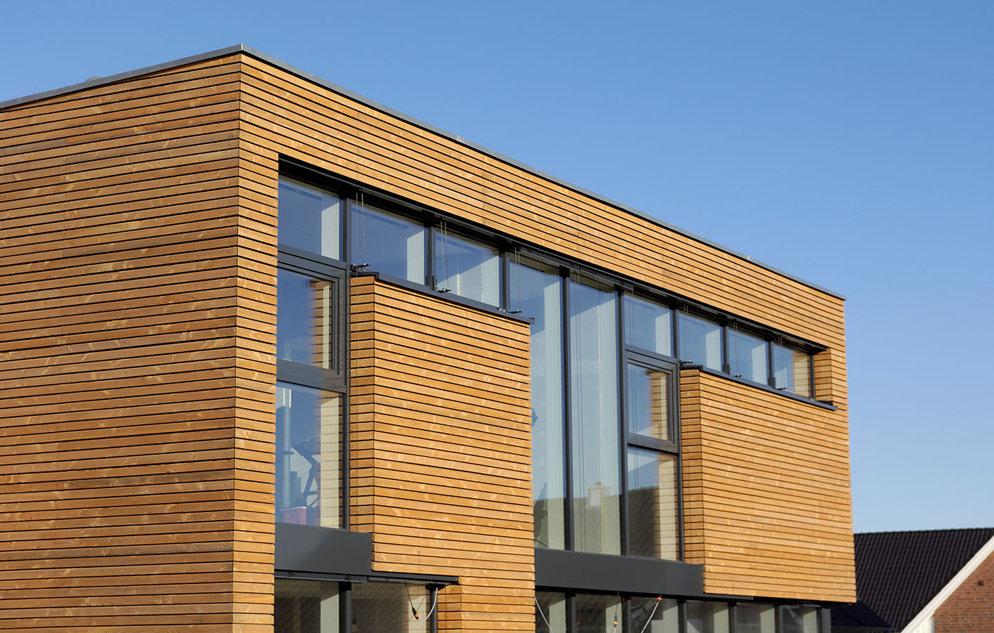 Holzfassade an einem Haus mit großer Glasfront.